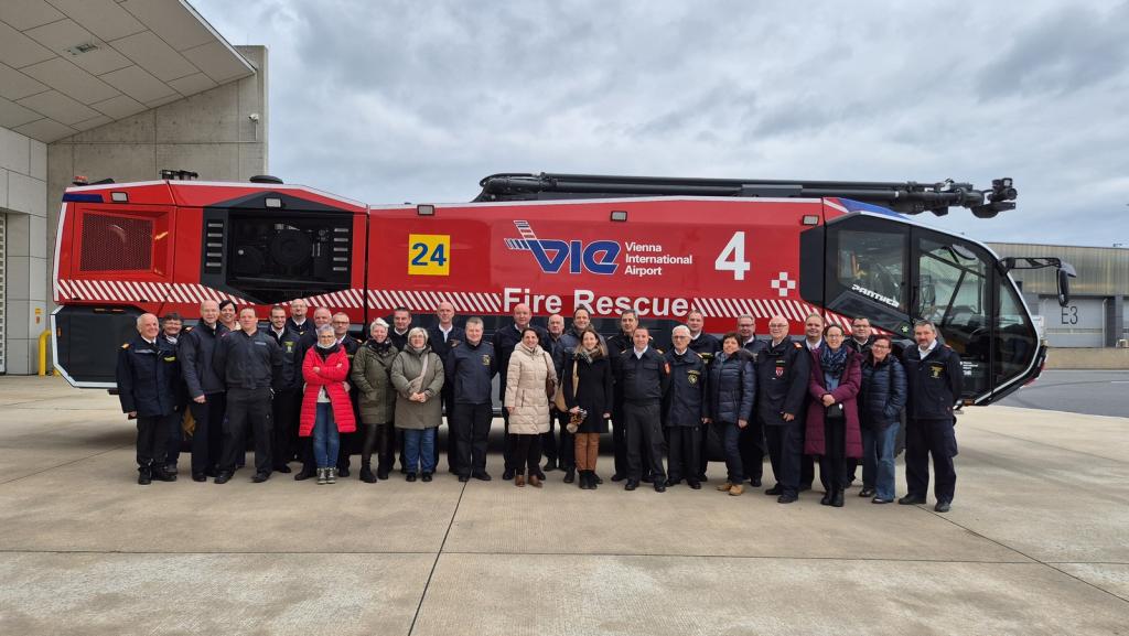 Besichtigung des Flughafens und der Flughafenfeuerwehr durch das BFKDO Wiener Neustadt - Teilnehmer vor Bluhafenlöschfahrzeug